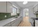 Bright kitchen features stainless steel appliances, ample counter space, and decorative green tile backsplash at 413 Top Greene Ln, Raleigh, NC 27601