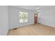 A well-lit living room featuring wood floors, a door to the side, and large window at 413 Top Greene Ln, Raleigh, NC 27601