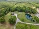 Aerial view of home with lush trees, long driveway, and a serene pond at 4659 Antioch Rd, Oxford, NC 27565
