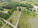 Aerial view of the land and pond with trees and a road at 4659 Antioch Rd, Oxford, NC 27565