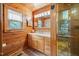 Wood-paneled bathroom featuring a shower, window with blinds, and a vanity with light wood cabinets at 4659 Antioch Rd, Oxford, NC 27565