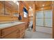 Bathroom with wood paneled walls, vanity, toilet, and shower with glass doors at 4659 Antioch Rd, Oxford, NC 27565