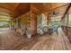 Spacious deck with log beams, a stone fireplace, rustic furniture, and views of the surrounding landscape at 4659 Antioch Rd, Oxford, NC 27565
