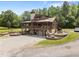 Log home featuring a large wraparound porch, stone accents, and a well-manicured yard at 4659 Antioch Rd, Oxford, NC 27565