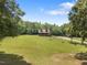 Log home surrounded by green grass and tall trees at 4659 Antioch Rd, Oxford, NC 27565