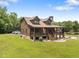 Charming log cabin with inviting porch, stone chimney, landscaped yard, and ample parking at 4659 Antioch Rd, Oxford, NC 27565