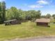 Outbuildings on green grass with a pond and trees in the background at 4659 Antioch Rd, Oxford, NC 27565