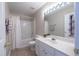 Inviting bathroom with white cabinets, tiled flooring, a large mirror, and tub-shower combination at 4933 Wyatt Brook Way, Raleigh, NC 27609