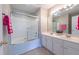 Well-lit bathroom featuring a bathtub with sliding glass doors and a double sink vanity at 4933 Wyatt Brook Way, Raleigh, NC 27609