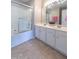 Bright bathroom featuring a tub with sliding glass doors, and double sink vanity with white cabinets at 4933 Wyatt Brook Way, Raleigh, NC 27609