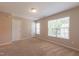 Spacious bedroom with carpet flooring, natural light from a large window, and white doors at 4933 Wyatt Brook Way, Raleigh, NC 27609
