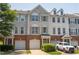 Townhome exteriors with brick accents, garages, and inviting curb appeal on a sunny day at 4933 Wyatt Brook Way, Raleigh, NC 27609