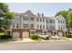 Townhome exteriors featuring brick foundations, garages, and well-maintained landscaping on a sunny day at 4933 Wyatt Brook Way, Raleigh, NC 27609