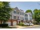 Townhome exteriors with brick and siding, complemented by green landscaping and private garages at 4933 Wyatt Brook Way, Raleigh, NC 27609