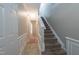 Bright hallway with staircase and white wainscoting for a stylish and welcoming entrance to the home at 4933 Wyatt Brook Way, Raleigh, NC 27609