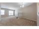 Spacious living room with neutral paint, plush carpet, large windows, and an elegant chandelier at 4933 Wyatt Brook Way, Raleigh, NC 27609