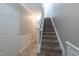 Carpeted staircase with a view of the entryway at 4933 Wyatt Brook Way, Raleigh, NC 27609