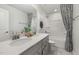 Bathroom featuring double sinks, grey cabinets, quartz counters, and a shower and tub combo with decorative shower curtain at 512 Providence Springs Ln, Fuquay Varina, NC 27526