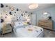 Charming bedroom featuring a fun, celestial-themed accent wall and stylish furnishings at 512 Providence Springs Ln, Fuquay Varina, NC 27526