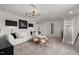 Living room with a white sectional sofa, round table with chairs, unique light fixture and an open doorway at 512 Providence Springs Ln, Fuquay Varina, NC 27526