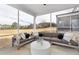 Relaxing screened-in patio with modern seating overlooking a spacious backyard and lush landscaping at 512 Providence Springs Ln, Fuquay Varina, NC 27526