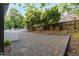 Backyard space includes a gravel area, mature trees, and fenced perimeter for privacy at 516 Ottawa Ave, Durham, NC 27701