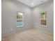 Bedroom featuring two large windows, neutral paint, and light hardwood flooring at 516 Ottawa Ave, Durham, NC 27701