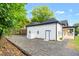 Exterior view of the home with gravel landscaping, white fence, and black roof at 516 Ottawa Ave, Durham, NC 27701