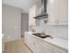 Bright kitchen with an island cooktop and stainless steel hood, along with white marble countertops at 516 Ottawa Ave, Durham, NC 27701