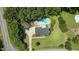 An aerial view of a two story home with lush lawn, mature trees and a backyard pool and detached garage at 5301 Night Heron Dr, Wake Forest, NC 27587