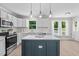 Kitchen features an island with bar stool seating, stainless steel appliances, and backyard views at 5301 Night Heron Dr, Wake Forest, NC 27587