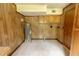 Utility room featuring a tile floor, wood paneling, storage cabinets, and a water heater at 5504 Balsam Pl, Raleigh, NC 27603