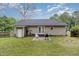 Backyard view showcasing an open lawn area, mature trees, a patio with chairs, and a BBQ grill at 5817 Seward Dr, Knightdale, NC 27545
