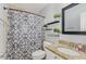 This bathroom showcases a decorative shower curtain, floating shelves, and a granite countertop at 5817 Seward Dr, Knightdale, NC 27545