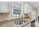 Granite countertops complement stainless appliances in this kitchen with a convenient double sink and bright window at 5817 Seward Dr, Knightdale, NC 27545