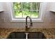 Close-up of the kitchen sink with granite countertops and a window view at 5949 Sandy Run, Knightdale, NC 27545