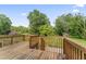Wooden back deck overlooks a lush yard with mature trees and a small storage shed at 6411 Pondview Ln, Durham, NC 27712