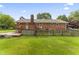 Brick home with wooden deck and large backyard with mature trees at 6411 Pondview Ln, Durham, NC 27712