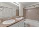 Bathroom featuring double sinks, neutral tile, and a bathtub with shower at 6411 Pondview Ln, Durham, NC 27712