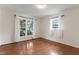 A bright bedroom shows hardwood floors and two windows for an airy feel at 6411 Pondview Ln, Durham, NC 27712