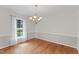 Elegant dining room featuring hardwood floors, a chandelier, and a view of the outdoors through a window at 6411 Pondview Ln, Durham, NC 27712