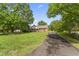 Well-maintained brick home with a large front yard, mature trees, and an inviting driveway at 6411 Pondview Ln, Durham, NC 27712