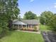Aerial view of a single-story brick home with a well-maintained lawn and mature trees at 6411 Pondview Ln, Durham, NC 27712