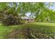 A traditional brick home sits surrounded by mature trees and a well-kept lawn at 6411 Pondview Ln, Durham, NC 27712