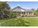 Charming brick home with manicured lawn, flowering bushes, and a covered front porch at 6411 Pondview Ln, Durham, NC 27712
