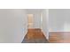Hallway with hardwood floors leading to a full bathroom with tile flooring at 6411 Pondview Ln, Durham, NC 27712
