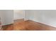 Hallway with hardwood flooring transitions to tiled flooring, connecting different areas of the home at 6411 Pondview Ln, Durham, NC 27712