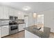 Bright kitchen featuring stainless steel appliances and a central island with granite countertops at 6411 Pondview Ln, Durham, NC 27712