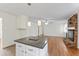 Open-concept kitchen island adjacent to a living room with a brick fireplace, perfect for entertaining at 6411 Pondview Ln, Durham, NC 27712