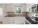 Well-lit kitchen with stainless steel appliances, sleek countertops, and a window overlooking the greenery at 6411 Pondview Ln, Durham, NC 27712